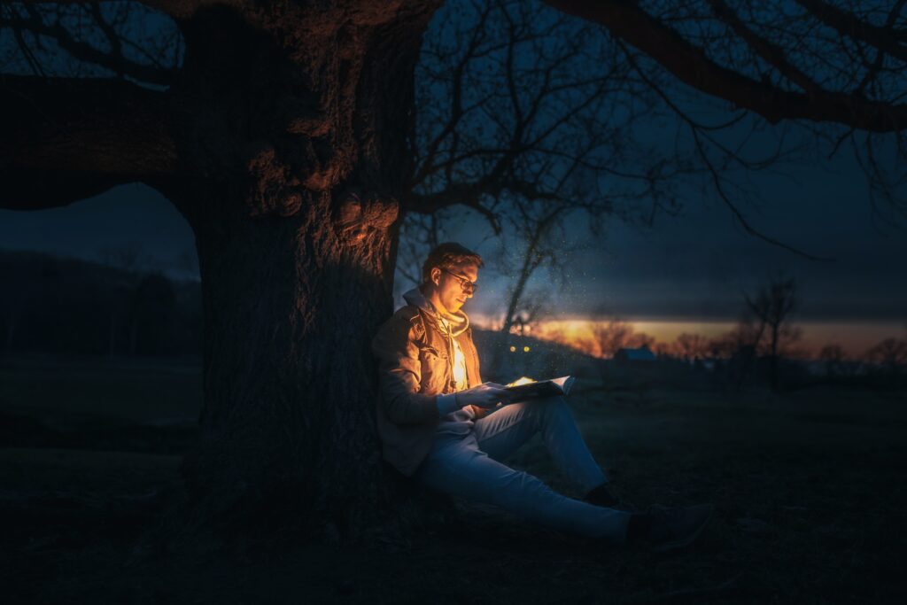 persoon leest in donkere omgeving en alleen boek is verlicht