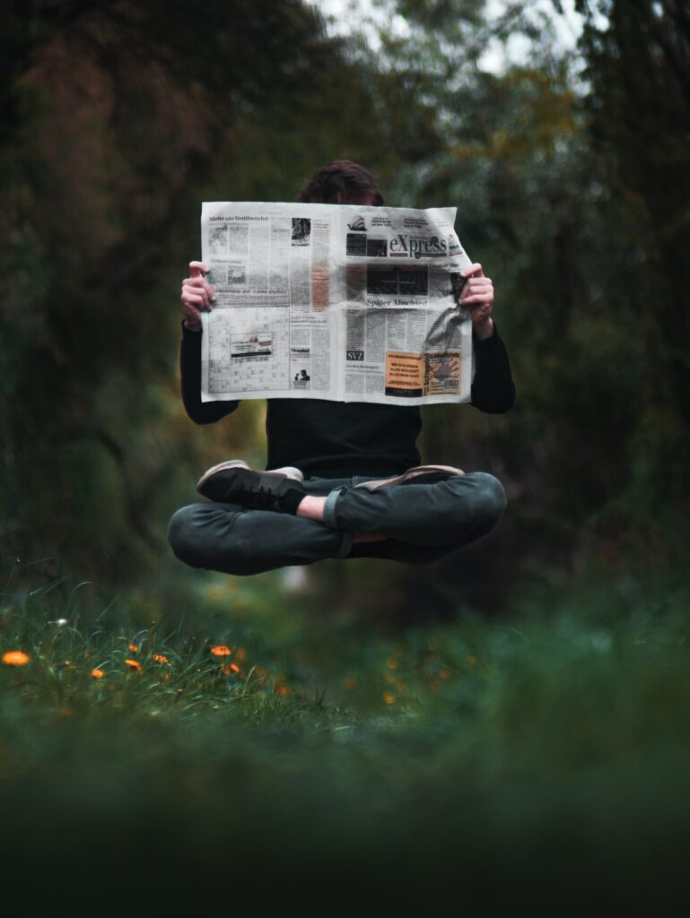 Zwevend persoon leest krant 