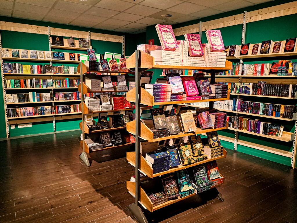 Boekwinkel met groot assortiment genreboeken in wandkasten en losstaande kasten